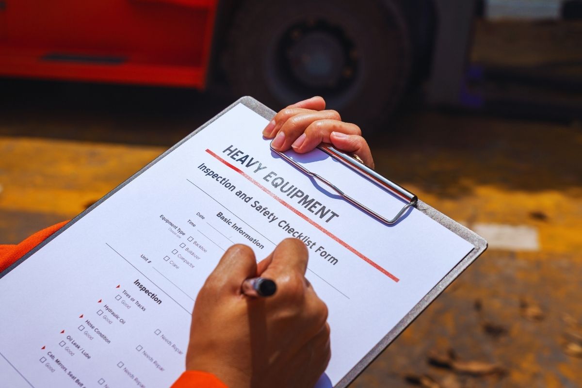 Technician completing a heavy equipment inspection checklist as part of routine forklift maintenance.