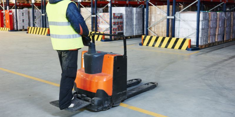 pallet stacker (1) The person in the warehouse is using a pallet stacker.